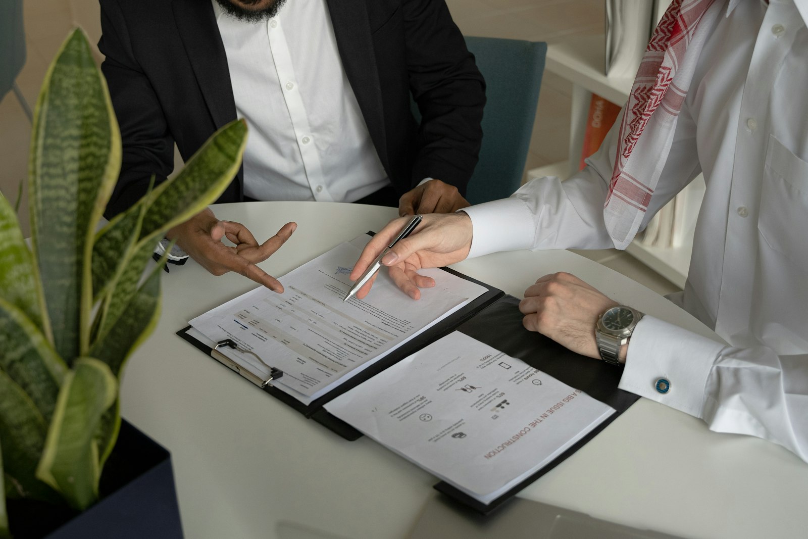 Two people reviewing business documents and paperwork at a desk